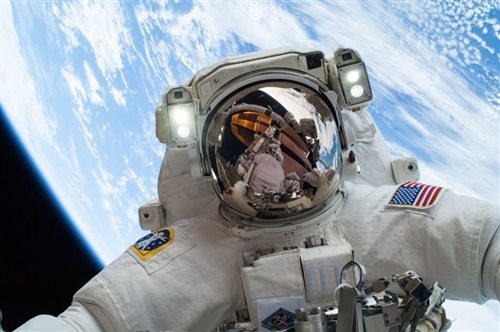 Dr. Iman Al-Rashidi in a spacesuit with Earth in the background
